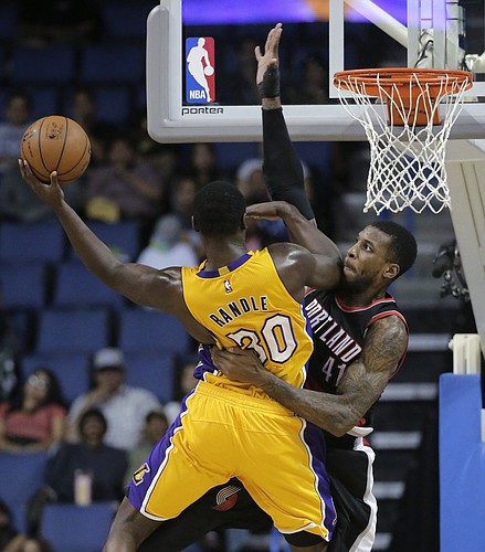 Los Angeles Lakers' Julius Randle, left, goes up for a shot against Portland Trail Blazers' Thomas Robinson during the second half of a preseason NBA basketball game Wednesday, Oct. 22, 2014, in Ontario, Calif. The Lakers won 94-86. (AP Photo/Jae C. Hong)
