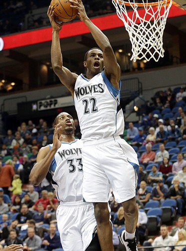 Minnesota Timberwolves rookie Andrew Wiggins goes up to dunk in the first quarter of an NBA preseason basketball game against the Philadelphia 76ers, Friday, Oct. 10, 2014, in Minneapolis. Watching, left, is Thaddeus Young. (AP Photo/Jim Mone)
