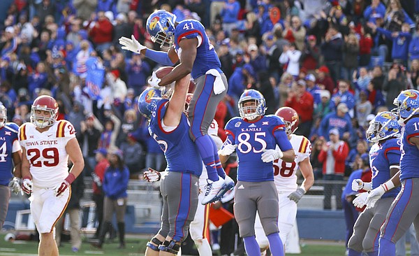Kansas offensive lineman Mike Smithburg hoists up tight end Jimmay Mundine after Mundine's touchdown against Iowa State during the first quarter on Saturday, Nov. 8, 2014.