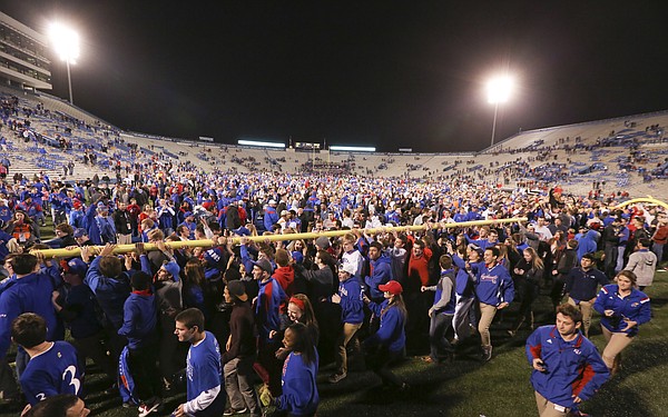 Kansas University football fans march with and upright to Potter Lake following the Jayhawks' 34-14 win over the Cyclones on Saturday, Nov. 8, 2014.