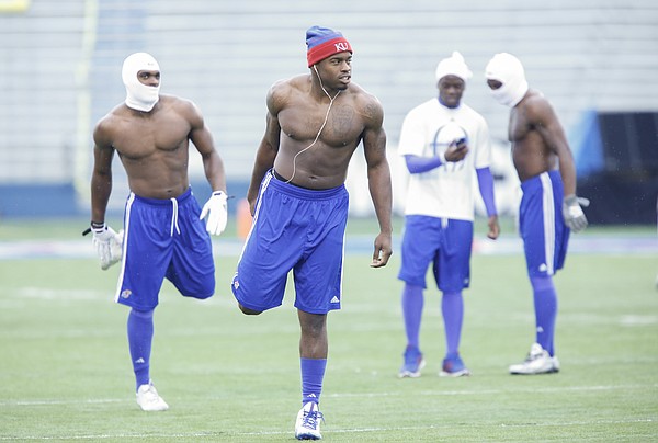 A shirtless Kansas linebacker Michael Reynolds, center,  stretches prior to kickoff against TCU on Saturday, Nov. 14, 2015 at Memorial Stadium. Reynolds hit the field with bare chested teammates Isaiah Johnson and Dexter McDonald for warmups.