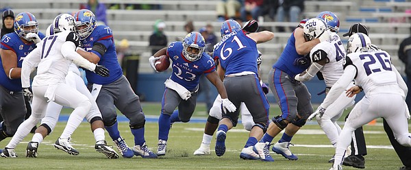 Kansas running back DeAndre Mann finds a hole up the middle against TCU during the second quarter on Saturday, Nov. 15, 2014 at Memorial Stadium.