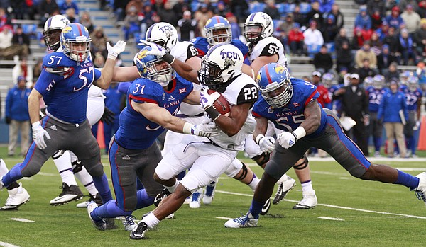 Kansas defenders Ben Heeney (31) and Michael Reynolds (55) look to bring down TCU receiver Aaron Green after a catch during the first quarter on Saturday, Nov. 15, 2014 at Memorial Stadium.