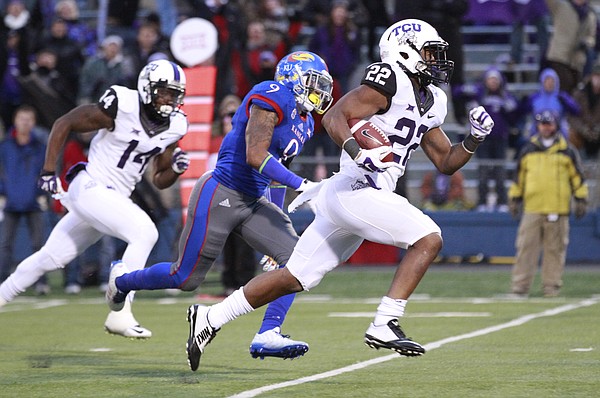 TCU running back Aaron Green races past Kansas safety Fish Smithson for a touchdown during the third quarter on Saturday, Nov. 15, 2014 at Memorial Stadium.