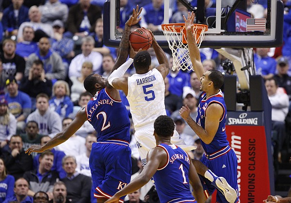 Kentucky guard Andrew Harrison (5) gets to the bucket between Kansas forward Cliff Alexander (2) and forward Perry Ellis (34) during the second half of the Champions Classic on Tuesday, Nov. 18, 2014 at Bankers Life Fieldhouse in Indianapolis.