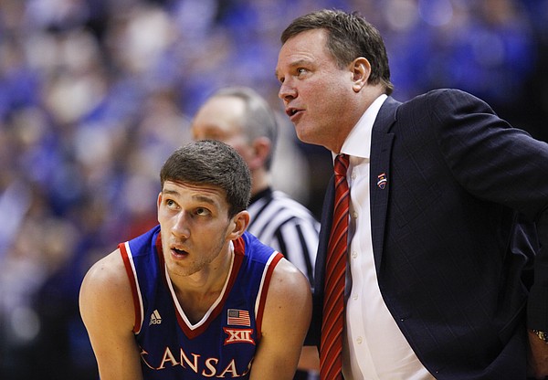 Kansas guard Sviatoslav Mykhailiuk leans down for a talk with head coach Bill Self during the second half of the Champions Classic on Tuesday, Nov. 18, 2014 at Bankers Life Fieldhouse in Indianapolis.
