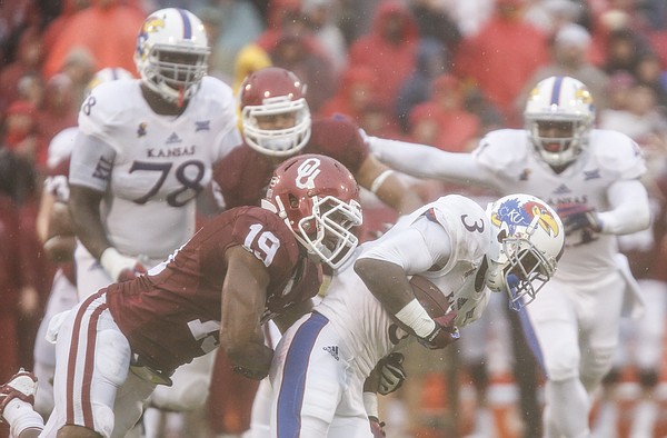 Kansas wide running back Tony Pierson (3) is dragged down by Oklahoma linebacker Eric Striker (19) during the quarter on Saturday, Nov. 22, 2014 at Memorial Stadium in Norman, Oklahoma.
