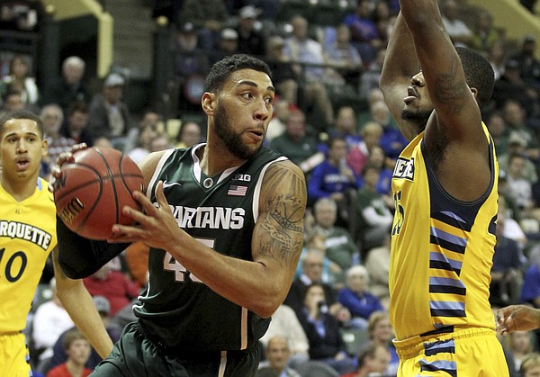 Michigan State guard Denzel Valentine (45) drives past Marquette Golden forward Steve Taylor Jr. (25) during the first half of an NCAA college basketball game in Kissimmee, Florida. MSU on Sunday will face Kansas in the championship game of the Orlando Classic.