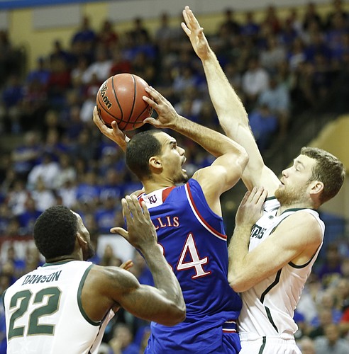 Kansas forward Perry Ellis (34) goes up for a shot against Michigan State forward Matt Costello (10) and forward Branden Dawson (22) during the first half on Sunday, Nov. 30, 2014 at the HP Field House in Kissimmee, Florida.