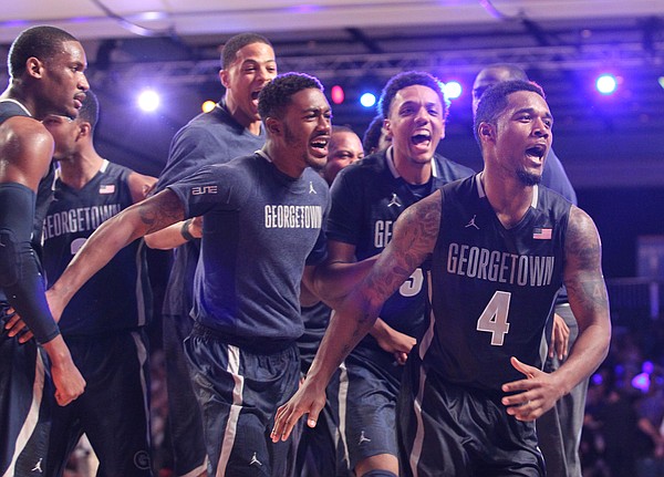 Georgetown's D'Vauntes Smith-Rivera (4), front, who scored the game-point, is surrounded by teammates as they celebrate their victory over Florida in the Battle 4 Atlantis basketball tournament in Paradise Island, Bahamas, Wednesday Nov. 26, 2014. (AP Photo/Tim Aylen)
