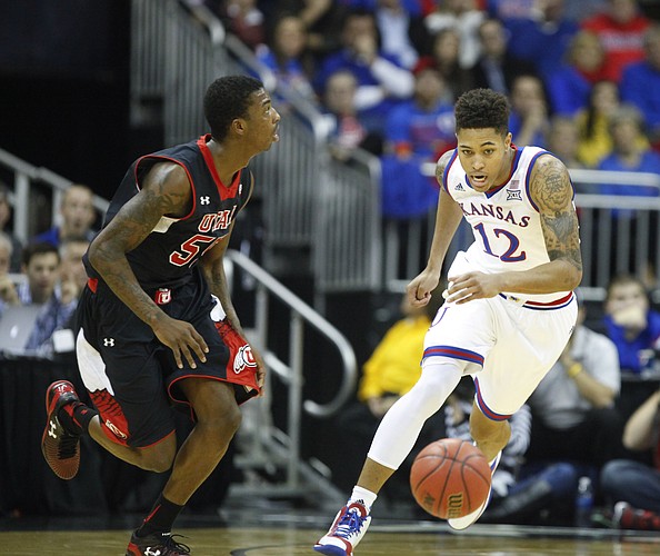 Kansas guard Kelly Oubre Jr. (12) eyes the ball as he defends Utah guard Delon Wright (55) during the first half on Saturday, Dec. 13, 2014 at Sprint Center