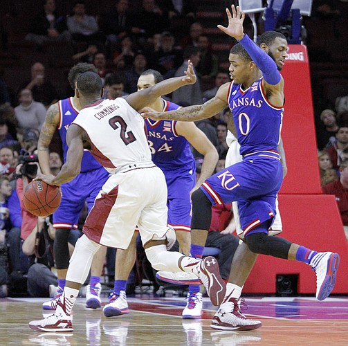 Kansas guard Frank Mason III (0) tries to slide by a screen chasing Temple guard Will Cummings (2) Monday at the Wells Fargo Center in Philadelphia, PA.