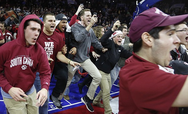 Temple fans run onto the court following the Jayhawk's 77-52 loss to the Owls Monday.