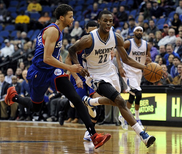 Minnesota Timberwolves forward Andrew Wiggins (22) moves the ball on a breakaway against Philadelphia 76ers guard Michael Carter-Williams (1) during the second quarter of an NBA basketball game Wednesday, Dec. 3, 2014, in Minneapolis. (AP Photo/Hannah Foslien)
