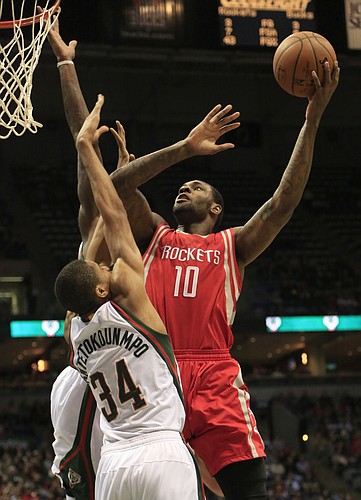 Houston Rockets forward Tarik Black, right, goes up for a basket against Milwaukee Bucks guard Giannis Antetokounmpo, left, during the first half of an NBA game Saturday, Nov. 29, 2014, in Milwaukee. (AP Photo/Darren Hauck)
