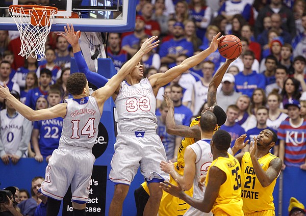 Kansas forward Landen Lucas (33) draws some contact from teammate Brannen Greene (14) as he blocks a shot by Kent State guard Kris Brewer (1) during the first half on Tuesday, Dec. 30, 2014 at Allen Fieldhouse.