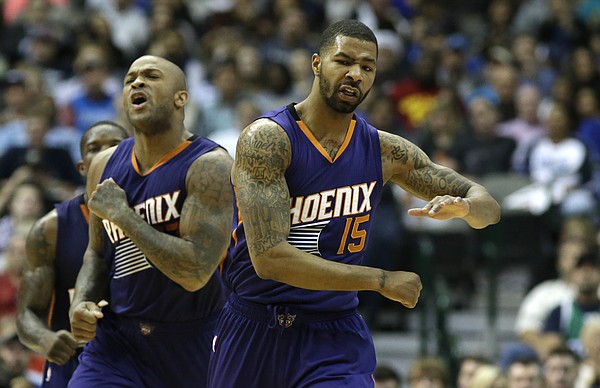 Phoenix Suns forwards Marcus Morris (15) and P.J. Tucker celebrate during the second half of an NBA basketball game against the Dallas Mavericks Friday, Dec. 5, 2014, in Dallas. (AP Photo/LM Otero)
