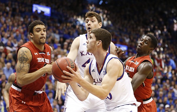 Kansas guard Sviatoslav Mykhailiuk (10) gets to the bucket past Texas Tech forward Justin Jamison (4) and guard Devaughntah Williams during the second half on Saturday, Jan.10, 2015 at Allen Fieldhouse. Also pictured is Kansas forward Hunter Mickelson.
