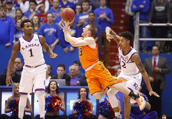 Oklahoma State guard Phil Forte III (13) throws up a shot after drawing contact from Kansas guard Kelly Oubre Jr. (12) during the first half, Tuesday, Jan. 13, 2015 at Allen Fieldhouse. At left is Kansas guard Wayne Selden Jr. (1).
