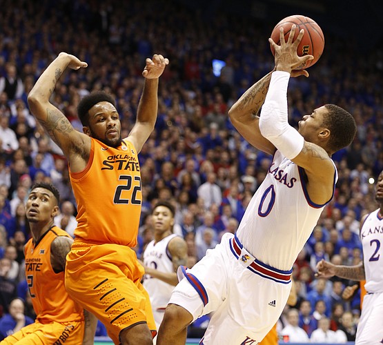 Kansas guard Frank Mason III (0) puts up a shot after being fouled by Oklahoma State guard Jeff Newberry (22) during the first half, Tuesday, Jan. 13, 2015 at Allen Fieldhouse.