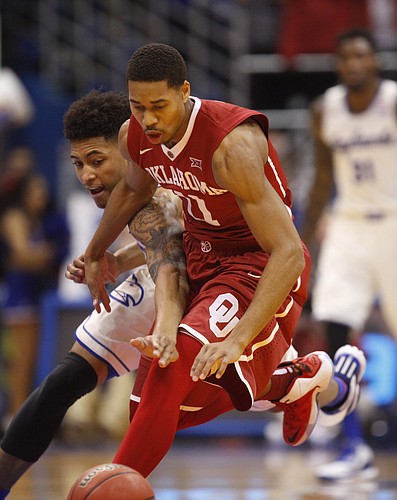 Kansas guard Kelly Oubre Jr. reaches through for a steal against Oklahoma guard Isaiah Cousins (11) during the first half on Monday, Jan. 19, 2015 at Allen Fieldhouse.