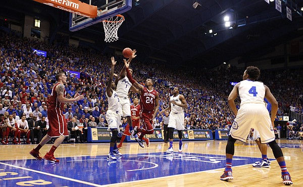 Oklahoma guard Buddy Hield (24) puts up a shot as he is defended by the Jayhawks during the second half on Monday, Jan. 19, 2015 at Allen Fieldhouse.