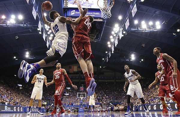 Kansas guard Kelly Oubre Jr. (12) pulls back for an attempted dunk as he attacks the basket against Oklahoma forward Ryan Spangler (00) during the second half on Monday, Jan. 19, 2015 at Allen Fieldhouse.