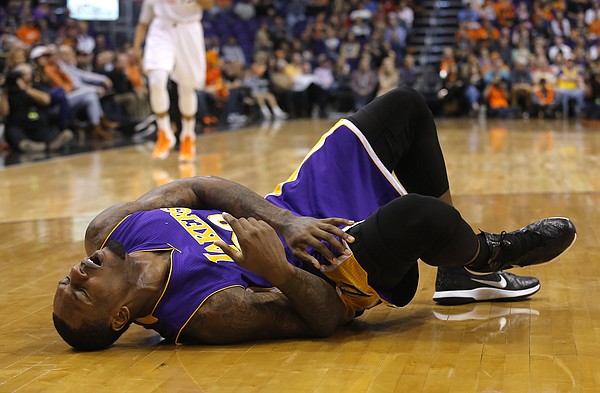 Los Angeles Lakers forward Tarik Black (28) reacts after getting hurt in the fourth quarter during an NBA basketball game against the Phoenix Suns, Monday, Jan. 19, 2015, in Phoenix. Black left the game and never returned. (AP Photo/Rick Scuteri)

