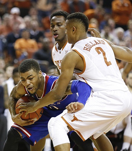 Kansas guard Frank Mason III (0) shrugs off Texas defenders Demarcus Holland (2) and guard Kendal Yancy during the second half, Saturday, Jan. 24, 2015 at Frank Erwin Center in Austin, Texas.