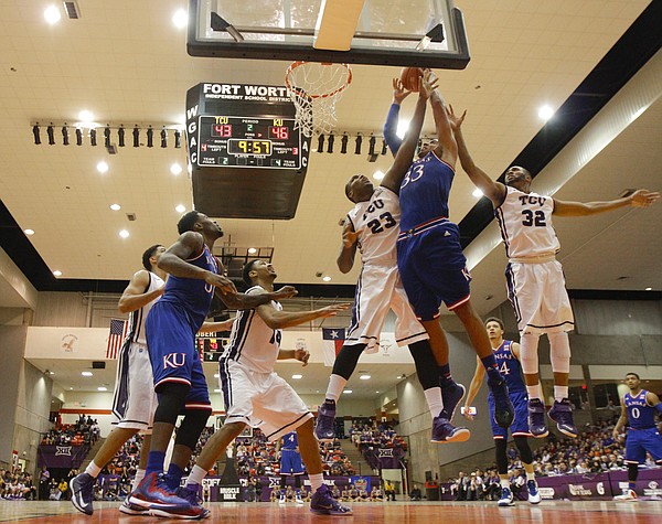 Kansas forward Landen Lucas (33) is fouled on his way to the bucket while defended by TCU Horned Frogs forward Devonta Abron (23) and guard Trey Zeigler (32) during the second half at Wilkerson-Greines Activity Center on Wednesday, Jan. 28, 2015 in Fort Worth, Texas.