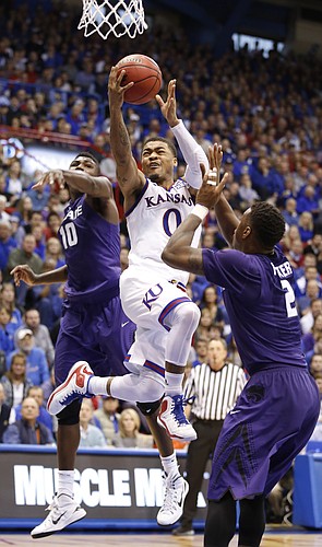 Kansas guard Frank Mason III (0) squeezes in for a bucket against Kansas State guard Malek Harris (10) and guard Marcus Foster (2) during the second half on Saturday, Jan. 31, 2015 at Allen Fieldhouse.