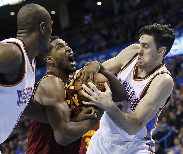 Cleveland Cavaliers forward Tristan Thompson, center, fights for the ball with Oklahoma City Thunder forward Serge Ibaka, left, and forward Nick Collison, right, in the second quarter of an NBA basketball game in Oklahoma City, Thursday, Dec. 11, 2014. Oklahoma City won 103-94. (AP Photo/Sue Ogrocki)
