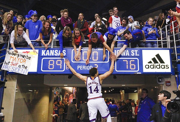 Kansas guard Brannen Greene slaps hands with the students seated above the scoreboard showing the Jayhawks' 89-76 victory over Iowa State on Monday, Feb. 2, 2015 at Allen Fieldhouse.