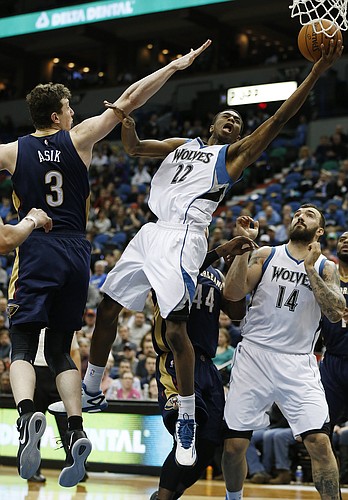 Minnesota Timberwolves forward Andrew Wiggins (22) pushes up to the basket against New Orleans Pelican center Omer Asik (3) during the second half of an NBA basketball game, Friday, Jan. 23, 2015, in Minneapolis. The Pelicans won 92-84. (AP Photo/Stacy Bengs)

