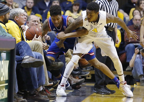 Kansas guard Kelly Oubre, Jr. (12) goes out of bound battling for a ball with West Virginia guard Daxter Miles Jr. (4) during the Jayhawks 62-61 loss game against the West Virginia Mountaineers Monday, February 16, 2105  in Morgantown, W.V.