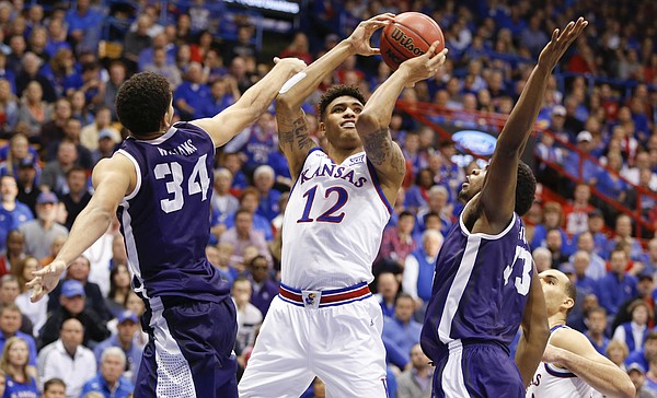 Kansas guard Kelly Oubre Jr. (12) hangs for a shot between TCU forward Kenrich Williams (34) and forward Chris Washburn during the second half, Saturday, Feb. 21, 2015 at Allen Fieldhouse.