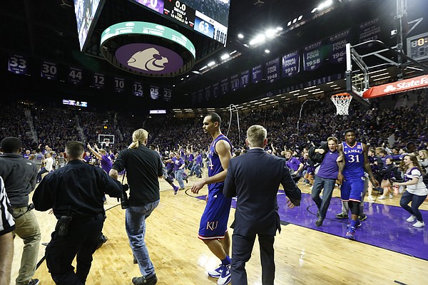 In this sequence of images a court-rusher checks Kansas forward Jamari Traylor on his way toward the Kansas players before being temporarily stopped by security.