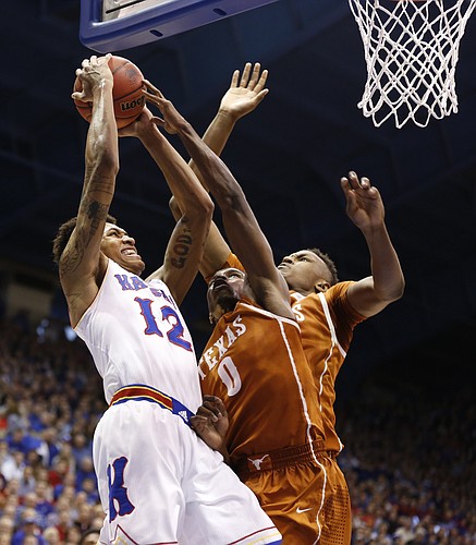 Kansas guard Kelly Oubre Jr. (12) goes hard to the bucket against Texas guard Kendal Yancy (0) and forward Myles Turner during the second half on Saturday, Feb. 28, 2015 at Allen Fieldhouse.