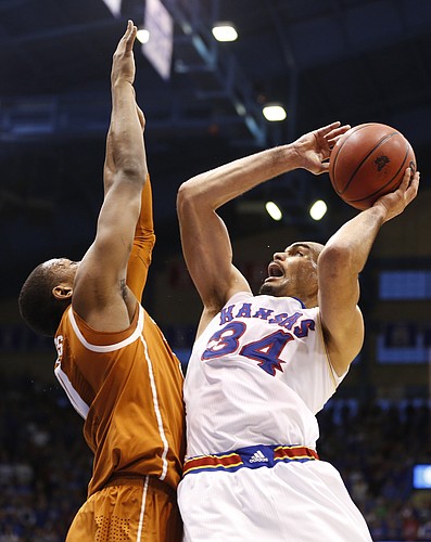 Kansas forward Perry Ellis hangs for a shot over Texas forward Jonathan Holmes during the second half on Saturday, Feb. 28, 2015 at Allen Fieldhouse.