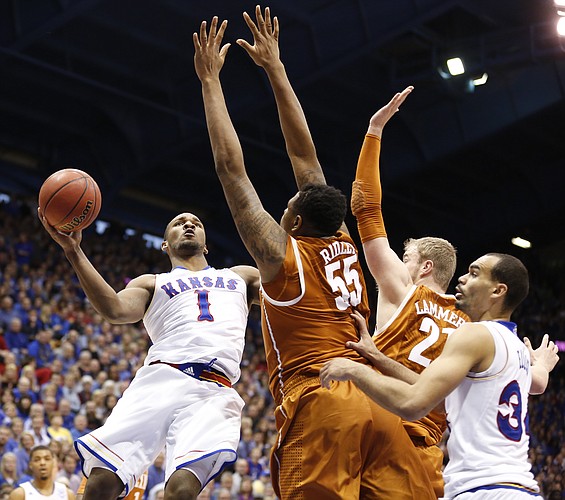 Kansas guard Wayne Selden Jr. (1) hangs for a shot against Texas center Cameron Ridley (55) and forward Connor Lammert during the second half on Saturday, Feb. 28, 2015 at Allen Fieldhouse. At right is Kansas forward Perry Ellis.
