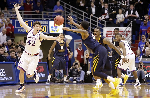 Kansas center Hunter Mickelson (42) knocks the ball loose to create a steal against the West Virginia Mountaineers Tuesday, March 4, 2015 at Allen Fieldhouse.