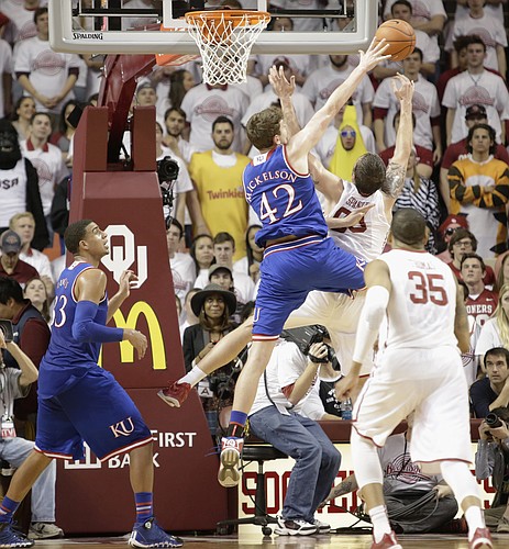 Kansas center Hunter Mickelson (42) blocks a shot  attempt by Oklahoma forward Ryan Spangler during the Jayhawks game Saturday, March 7, 2015 against the Oklahoma Sooners in Norman.