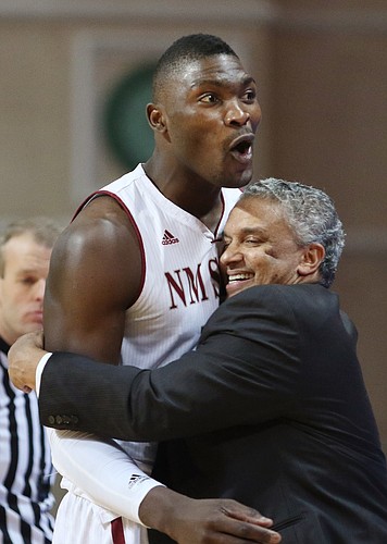 New Mexico State coach Marvin Menzies, right, hugs center Tshilidzi Nephawe toward the end of the second half of the Aggies’ victory over Cal State-Bakersfield in the semifinals of the Western Athletic Conference tournament on Friday in Las Vegas. Nephawe is one of four seniors Menzies will count on when the Aggies open the NCAA Tournament against Kansas on Friday in Omaha, Nebraska.