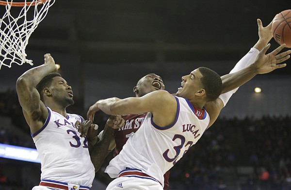 Kansas forward Jamari Traylor (31), left, and Landen Lucas (33) right, go for a rebound against New Mexico State center Tshilidzi Nephawe (15) in the Jayhawks second-round NCAA tournament game against New Mexico State Friday, March 20, 2015 at the CenturyLink Center, Omaha, Neb. 