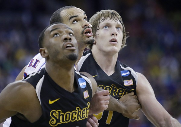 Kansas forward Perry Ellis (34) positions himself for a rebound against  Wichita State center Tom Wamukota, left and Ron Baker, left, in the first-half of the Jayhawks' third-round NCAA Tournament game against Wichita State Sunday, March 22, 2015.
