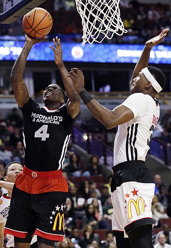 East forward Dwayne Bacon, left, of Oak Hill Academy, Mouth of Wilson, Va., shoots against West forward Carlton Bragg of Villa Angela-St. Joseph of Cleveland, during the second half of the McDonald's All-American boys basketball game in Chicago on Wednesday, April 1, 2015. The East won 111-91. (AP Photo/Nam Y. Huh)
