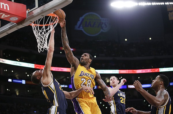 Los Angeles Lakers' Tarik Black, center, goes up for a basket during the second half of an NBA basketball game against the Utah Jazz, Thursday, March 19, 2015, in Los Angeles. The Jazz 80-73. (AP Photo/Jae C. Hong)