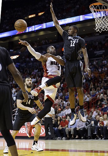 Miami Heat guard Dwyane Wade (3) passes against Minnesota Timberwolves guard Andrew Wiggins (22) in the second half of an NBA basketball game, in Miami, Saturday, Nov. 8, 2014. The Heat won 102-92. (AP Photo/Alan Diaz)
