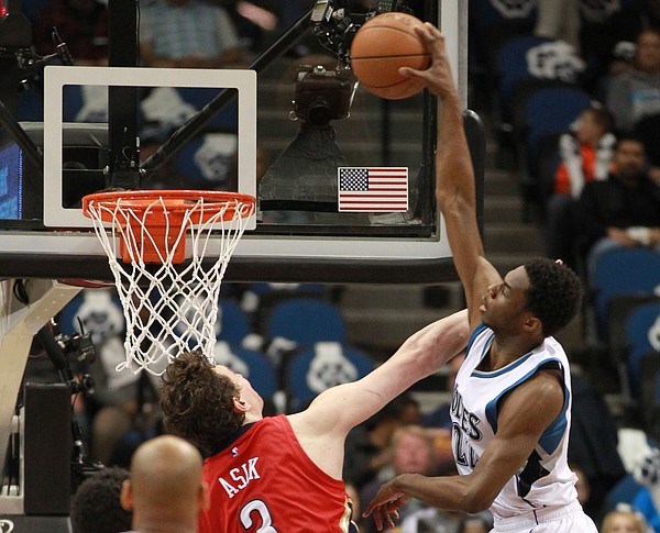 Minnesota Timberwolves Andrew Wiggins (22) dunks on New Orleans Pelicans Omer Asik in the half of an NBA basketball game Monday, April 13, 2015, in Minneapolis. (AP Photo/Andy Clayton-King)
