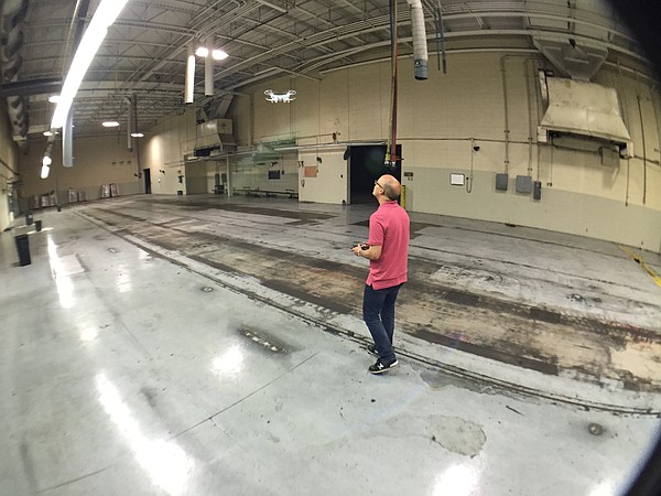 Journal-World photographer Nick Krug practices flying a small drone in the vacant room that once held the Journal-World printing press.